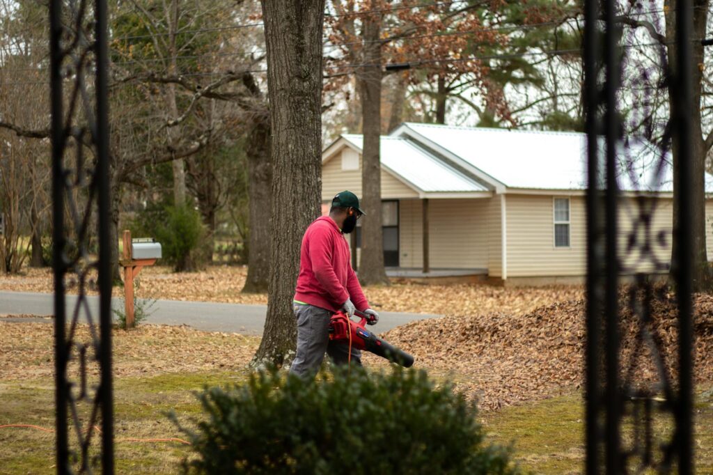 Certified arborist consulting with a homeowner during a tree health inspection in a suburban yard