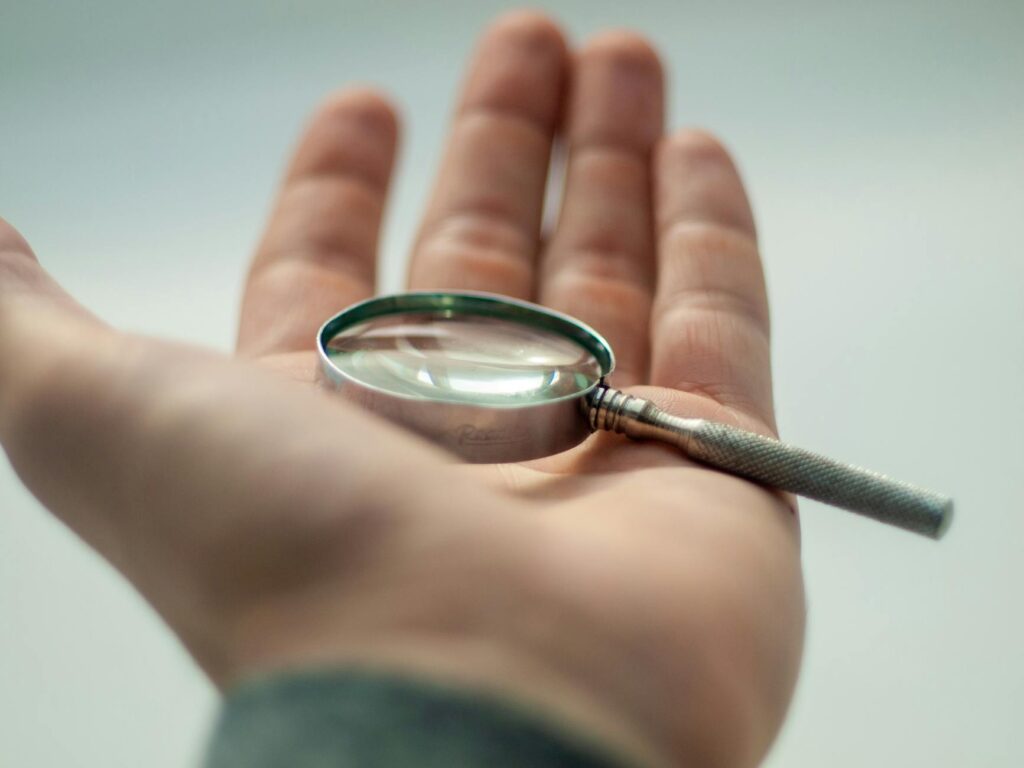 ISA-certified arborist closely examining tree bark with a hand lens to identify scale insect species