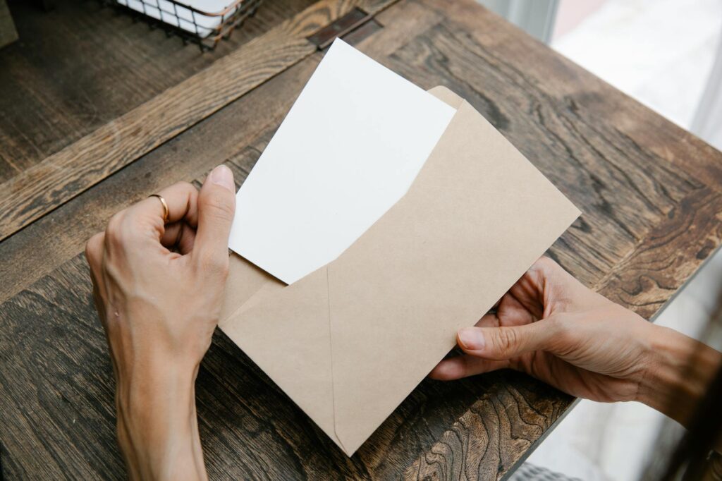 A person writing a formal letter to be sent via certified mail