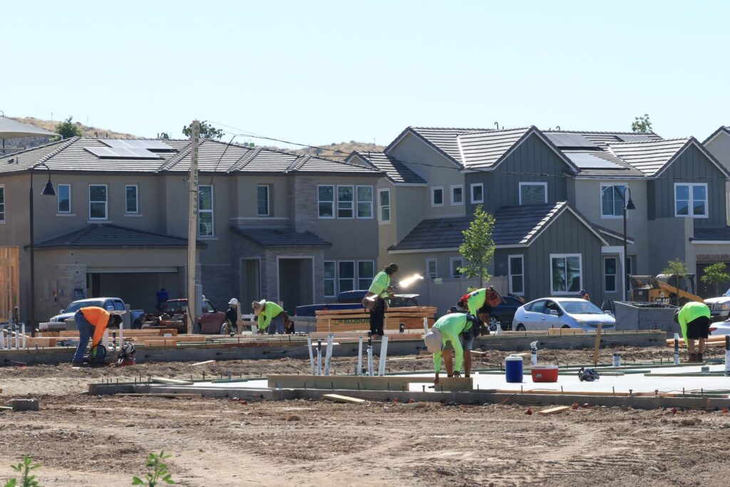 Construction crew near a large mature tree in a suburban New Jersey neighborhood