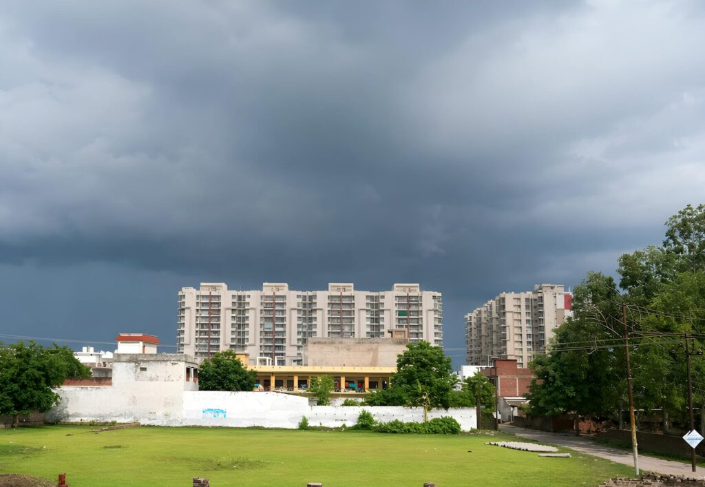 Dark storm clouds building over a residential neighborhood with large trees