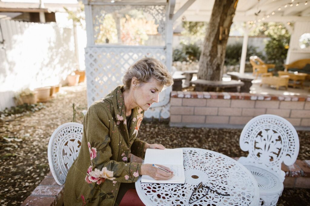 Homeowner taking notes while surveying trees in their backyard