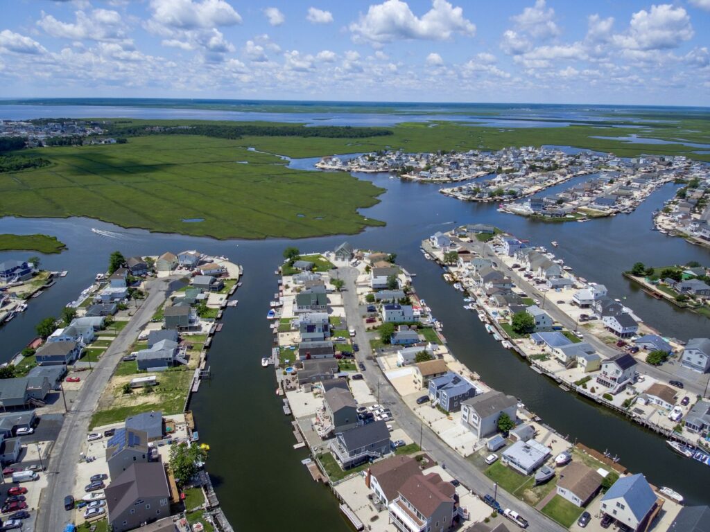 A coastal New Jersey neighborhood near Raritan Bay with large yard trees on a hot summer day