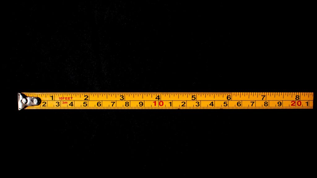Measuring planting distance from a house foundation before planting a new tree