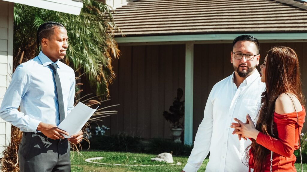 A certified arborist consulting with a homeowner about a front-yard tree