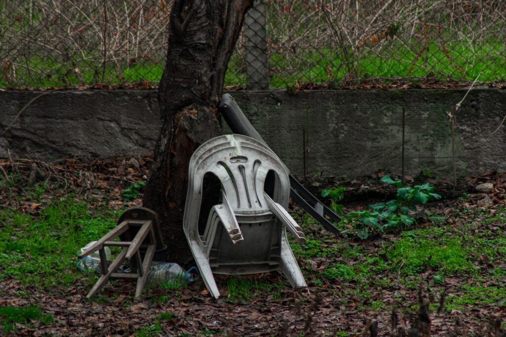 A broken limb hanging from a mature backyard tree after a storm