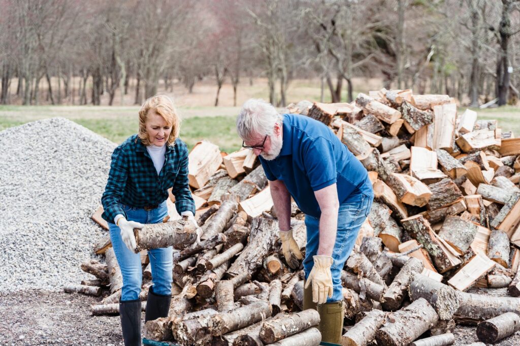 Homeowner sorting cut limbs into firewood and mulch piles